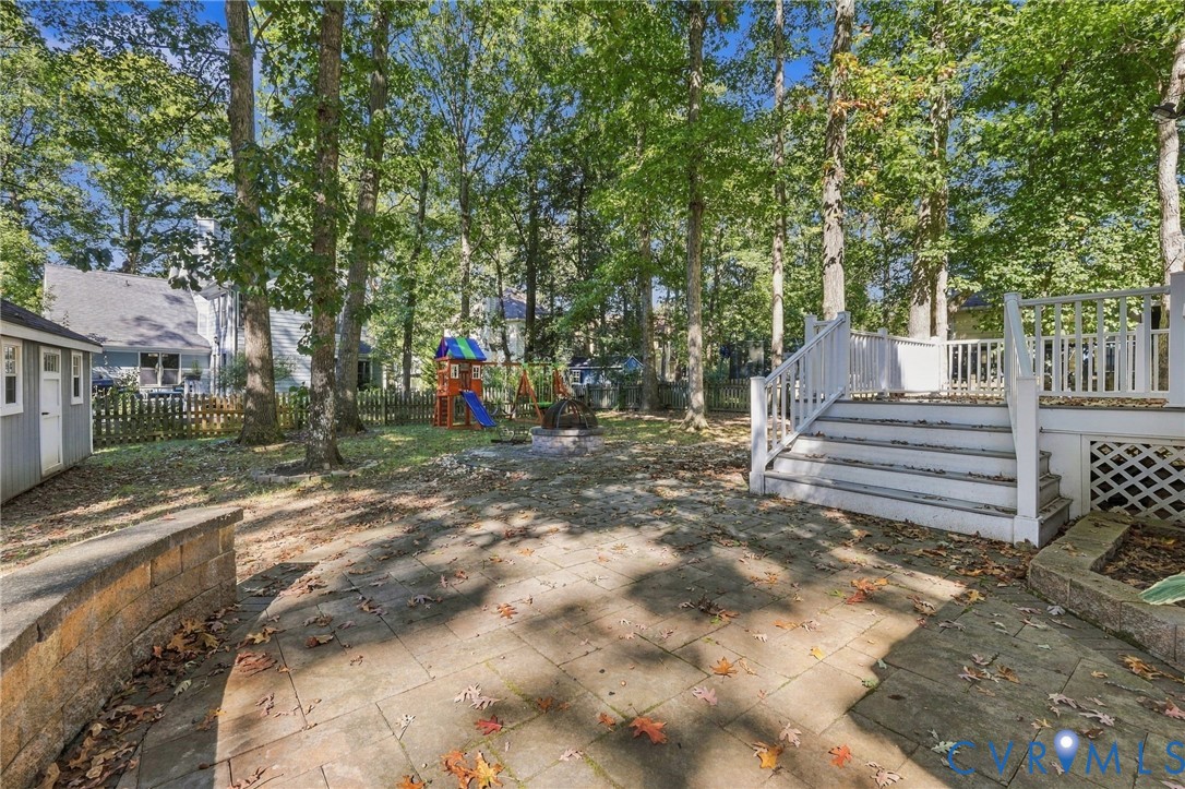 Spacious, tree-lined backyard featuring a paver patio, firepit area, and a nice flat lot.
