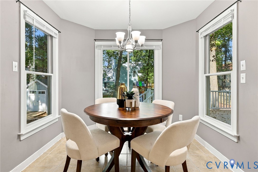 Bright breakfast nook surrounded by windows, offering a comfortable space for casual dining with views of the backyard.