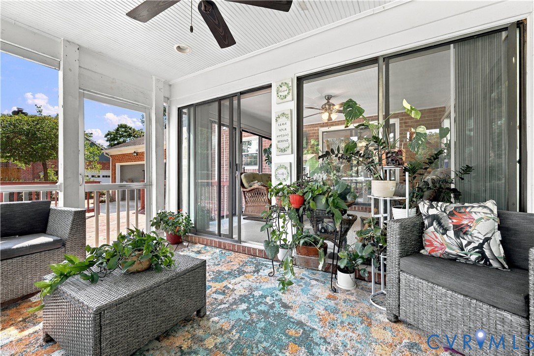 Enclosed porch featuring a beadboard ceiling, a ceiling-mounted fan, and sliding glass panel doors