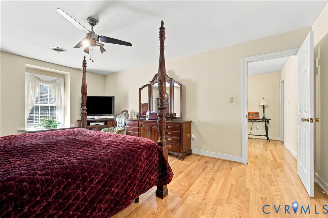 Room featuring wood-finish flooring, a ceiling fan with integrated lighting, and a recessed window with a deep sill