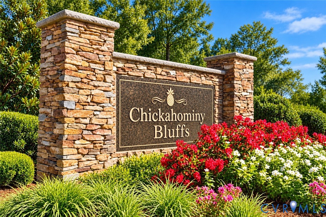Community monument sign featuring stacked stone pillars, decorative metal signage, and integrated landscaping with manicured shrubs and flowering perennials