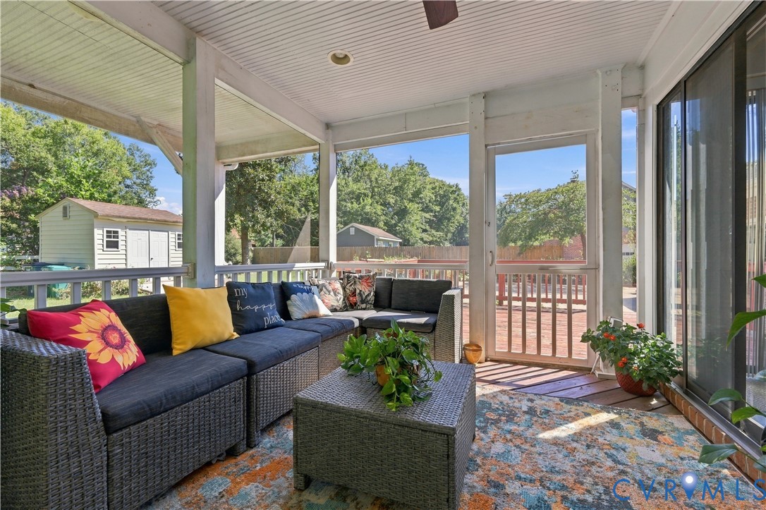 Screened-in porch featuring a beadboard ceiling, recessed lighting, ceiling fan, white railing, and a screen door leading to a wooden deck