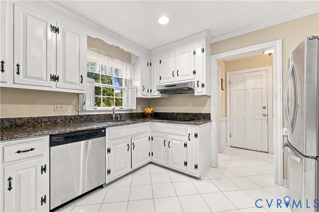 Kitchen featuring white shaker-style cabinetry, stone countertops, stainless steel appliances, and tile flooring