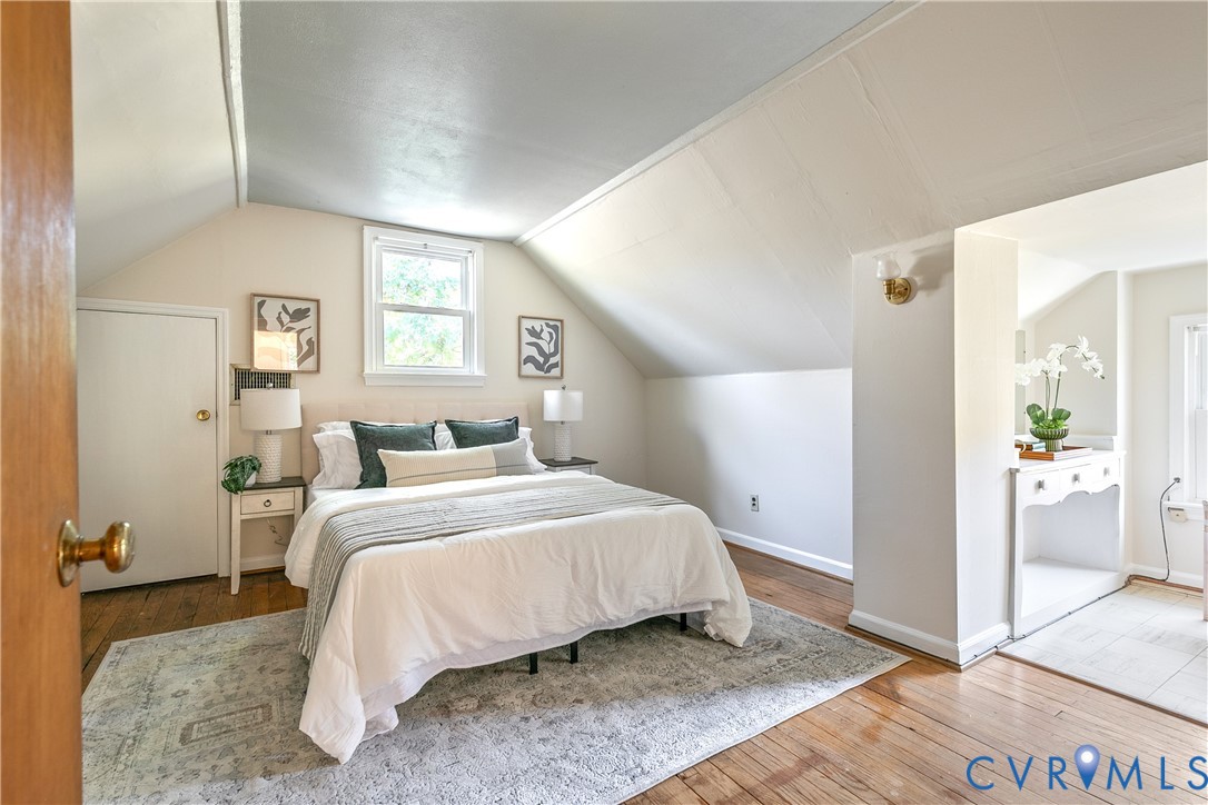 Dormer-style ceiling architecture featuring wood-finish flooring and a built-in vanity console