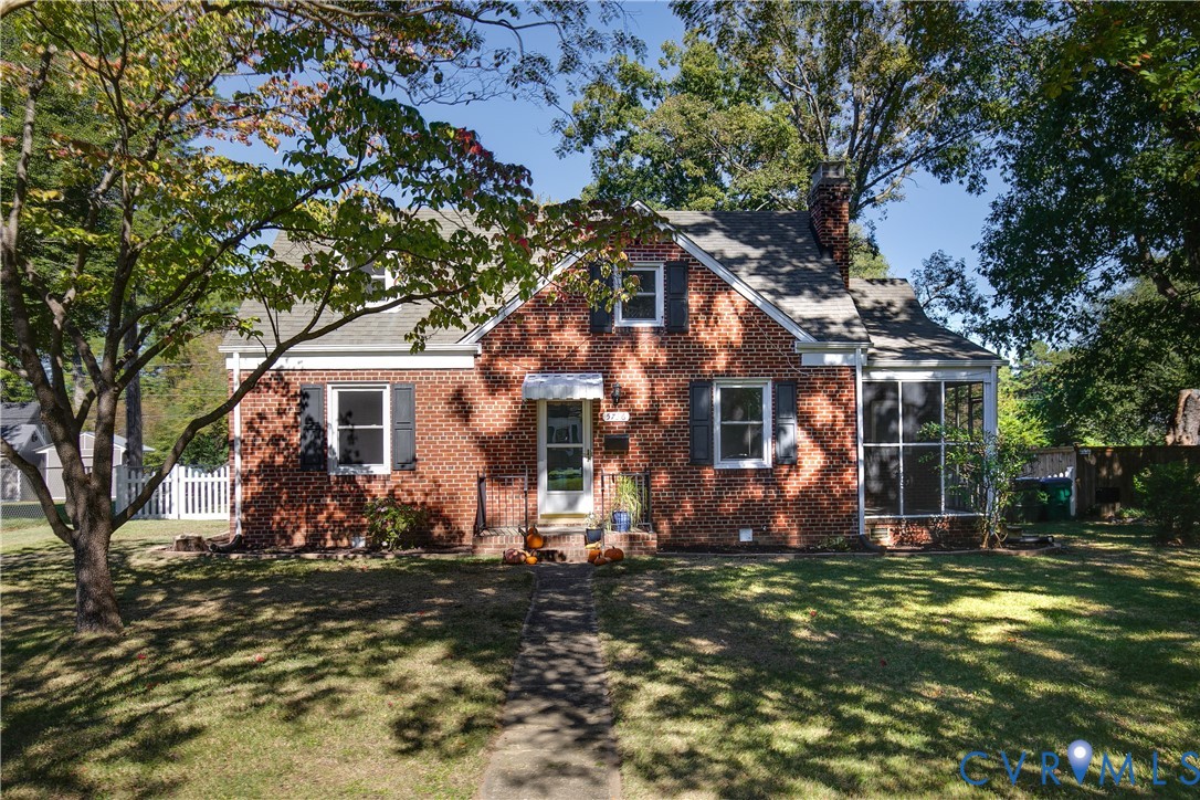 Traditional brick exterior featuring a steep-pitched roof, shuttered windows, a chimney, and a screened-in porch