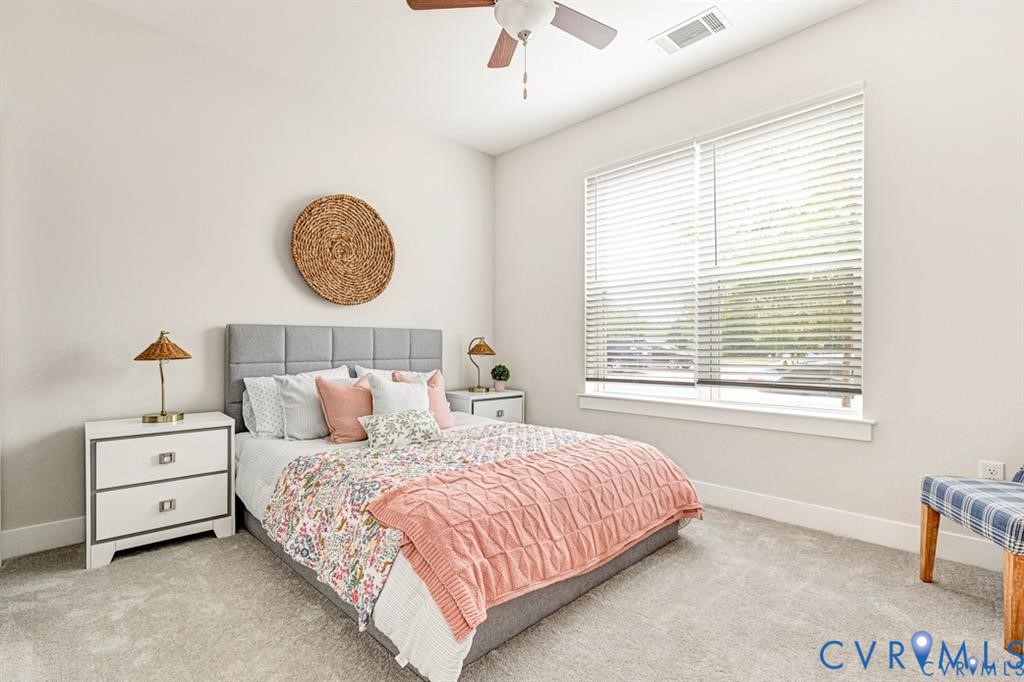 Neutral-toned wall paint, large window with horizontal blinds, ceiling fan, and wall-to-wall carpeting