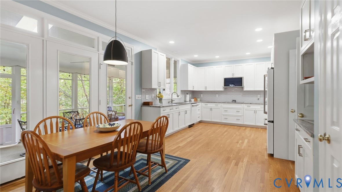 Kitchen featuring white shaker cabinetry, stone countertops, recessed lighting, wood-finish flooring, and multiple glass-paned doors