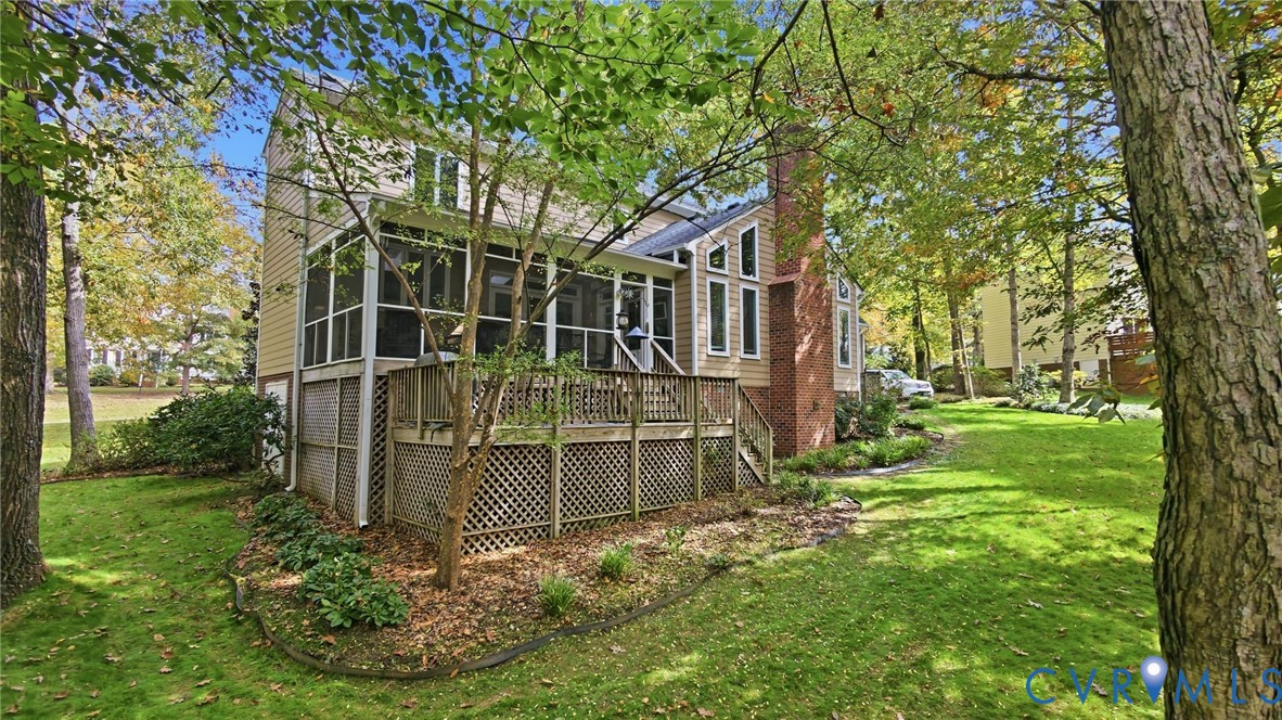 Rear exterior featuring a screened-in porch, multi-level wood deck, masonry chimney, and wood-siding facade