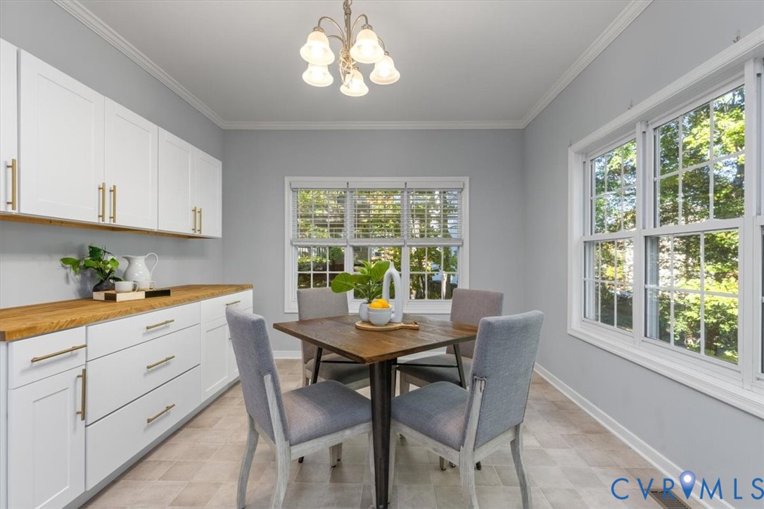 Large Eat in Kitchen with shaker-style white cabinetry for added storage and prep space with butcher block countertops and large windows