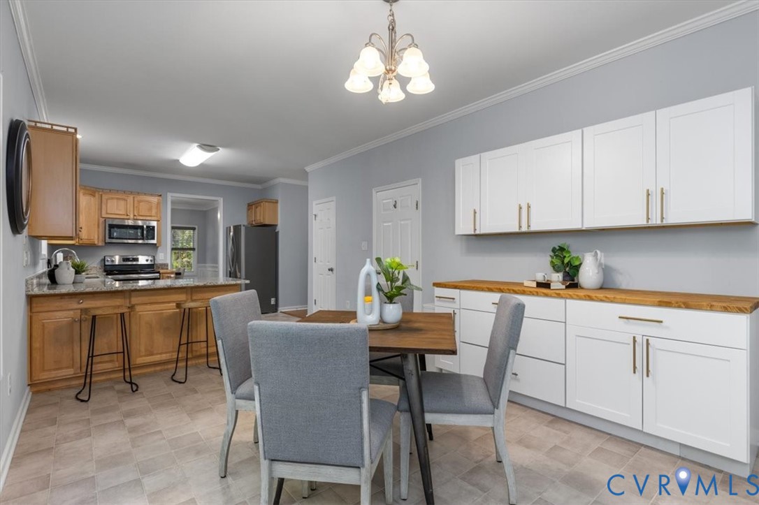 Large Eat in Kitchen with shaker-style white cabinetry for added storage and prep space with butcher block countertops and large windows