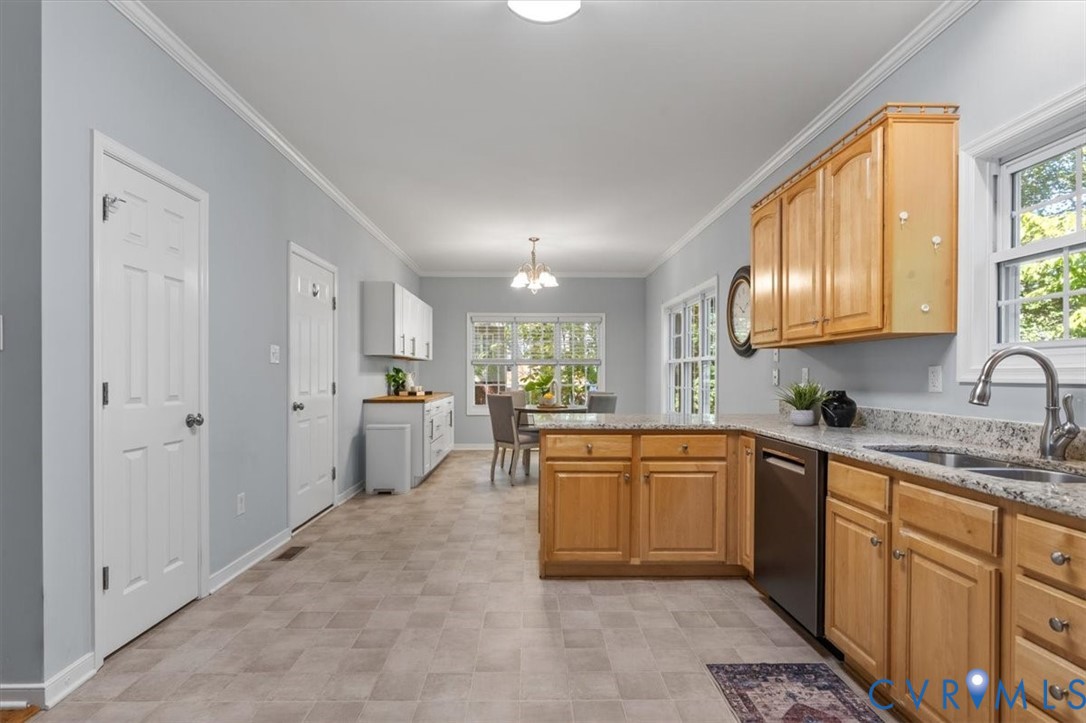 Kitchen featuring natural wood cabinetry, Granite countertops, stainless steel appliances, and vinyl flooring