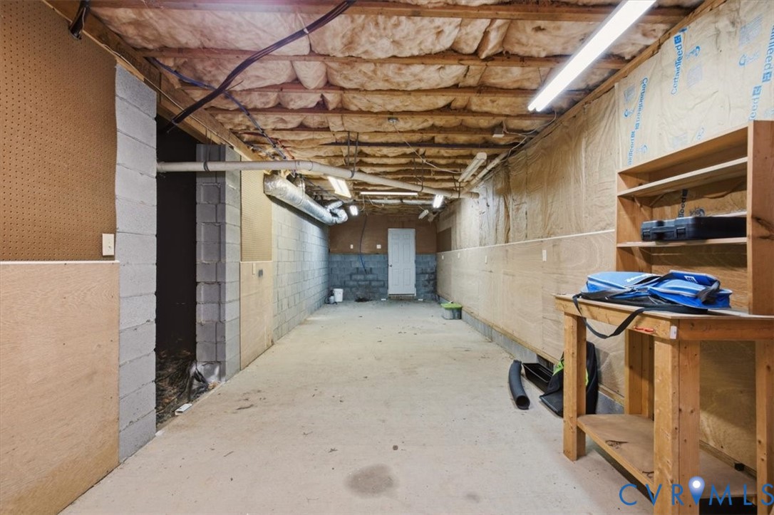 Large walk in crawlspace/unfinished basement area with lighting/electric.  Great for a workshop or added storage