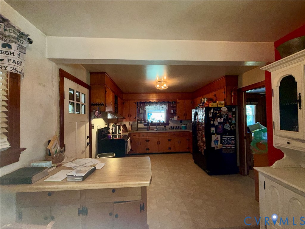 Kitchen featuring natural wood cabinetry, integrated storage island with countertop, and flush-mount ceiling lighting