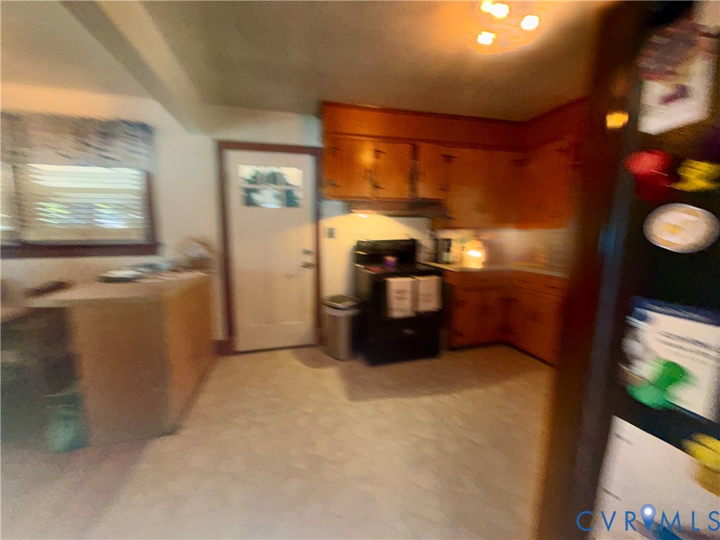 Kitchen featuring wooden cabinetry, solid-surface countertops, and a full-sized range
