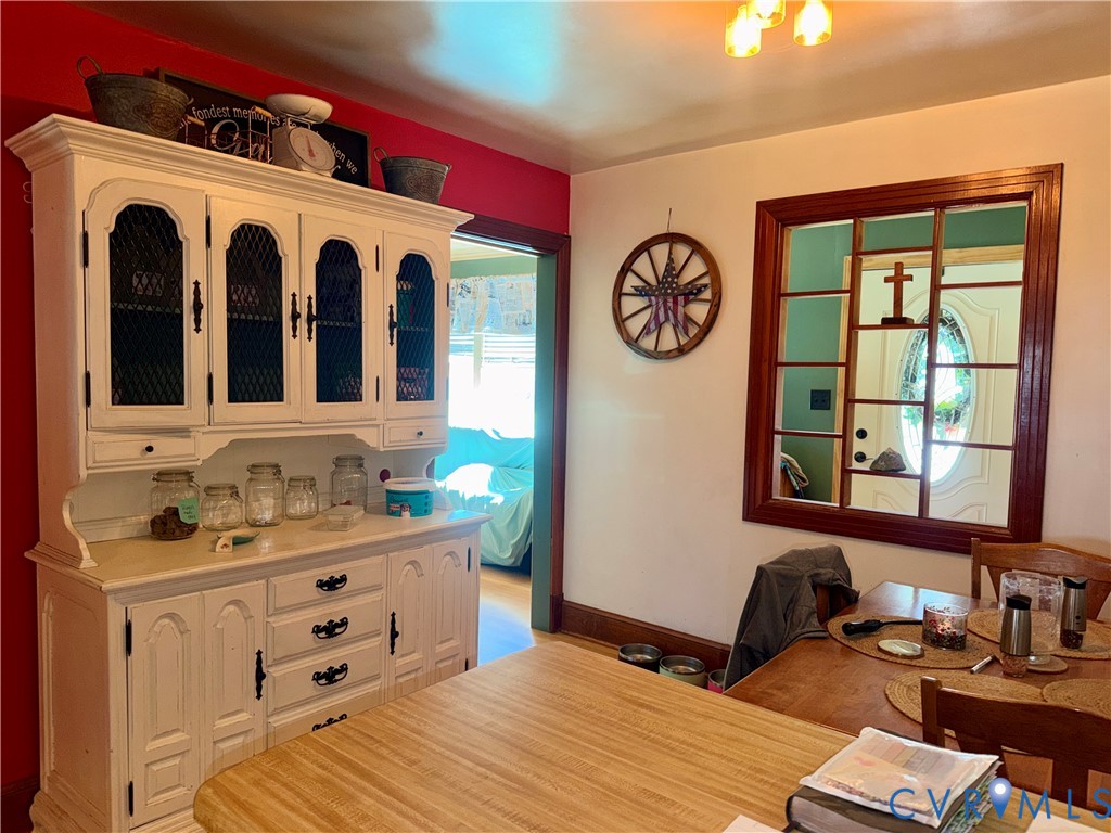 Built-in white hutch featuring upper glass-panel cabinetry and lower drawers, complemented by a decorative interior wooden window frame
