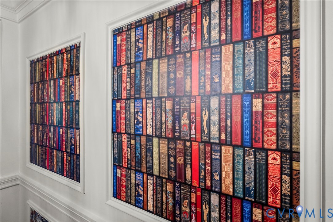 Wall panels featuring vibrant, book-spine patterned wallpaper enclosed by decorative white molding