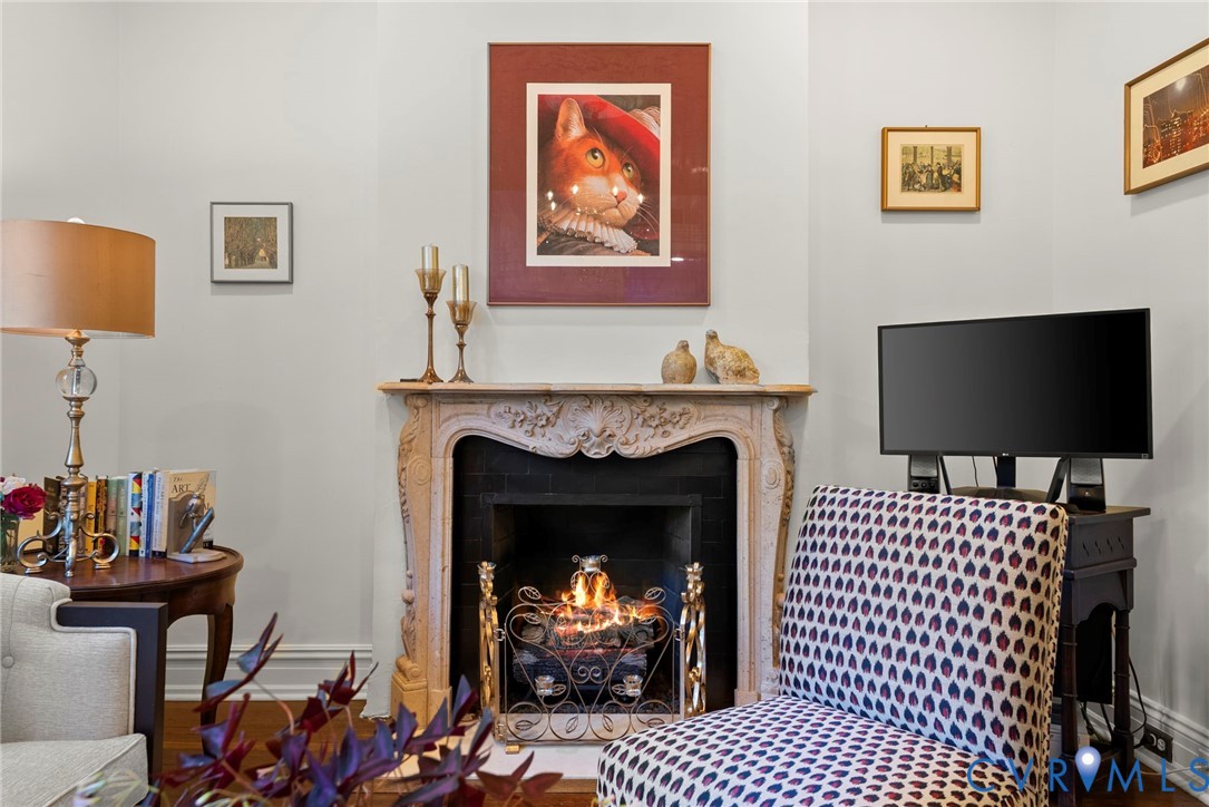 Ornate stone-carved fireplace mantel with a dark tile surround
