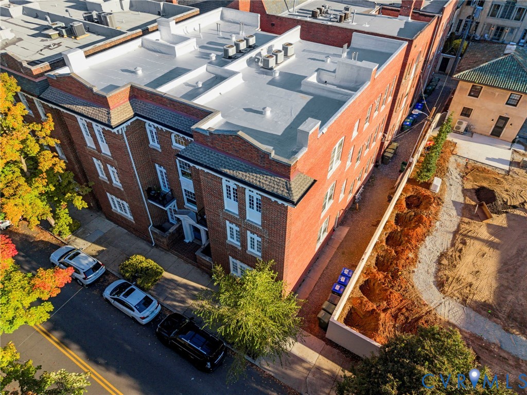 Multi-story brick exterior featuring decorative cornice detailing, individual balconies, and a flat roofline