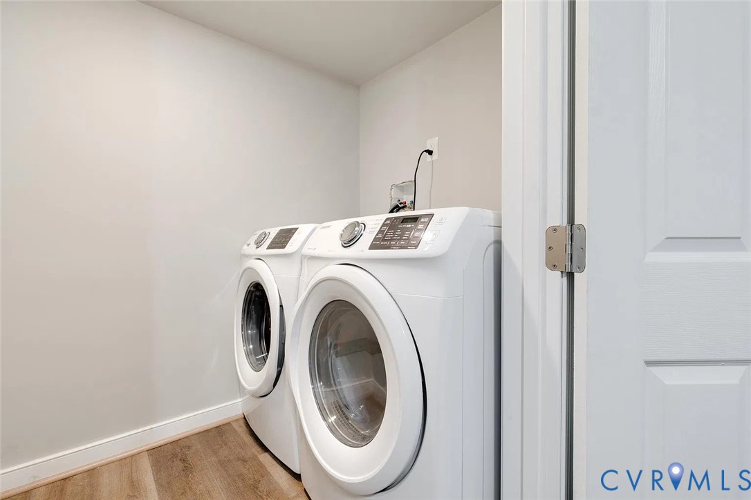 Utility area featuring wood-finish flooring and a white paneled door