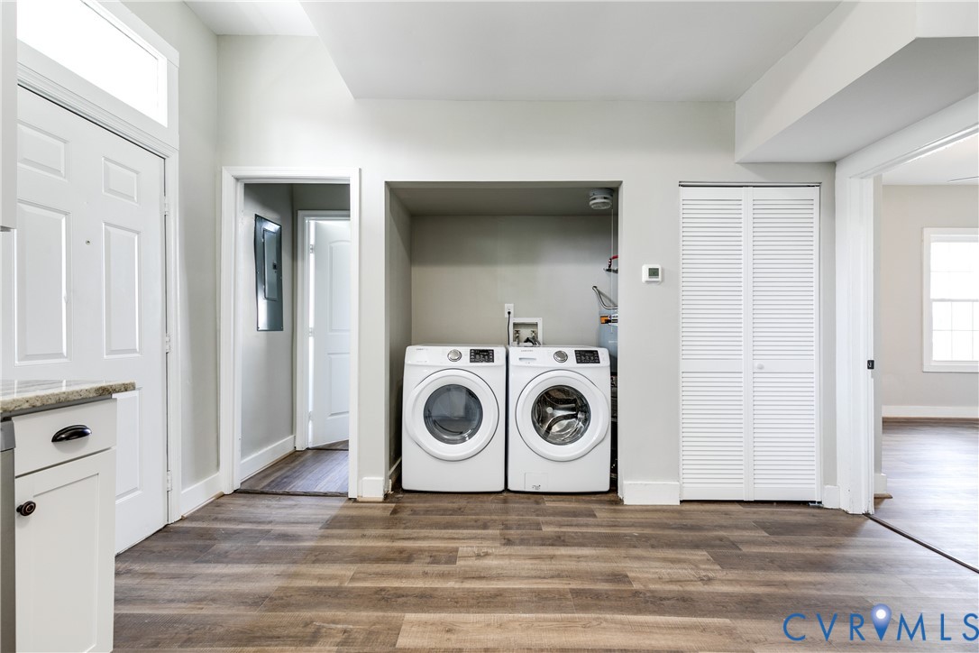 Utility area featuring wood-finish flooring, white cabinetry with stone-finish countertops, louvered-door closet, and recessed laundry hookups