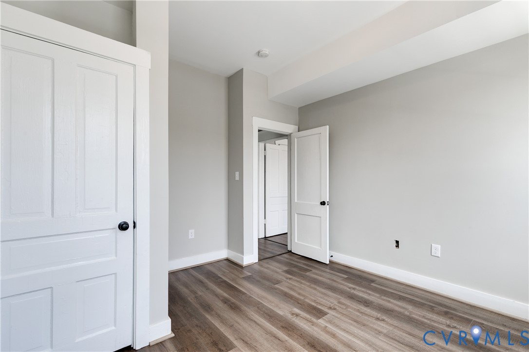 Neutral interior featuring wood-finish flooring, white two-panel doors, and crisp neutral wall paint