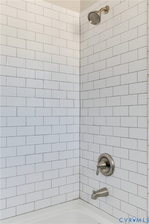 Subway-tile shower surround with a brushed-nickel showerhead, single-handle pressure-balance valve, and matching tub spout