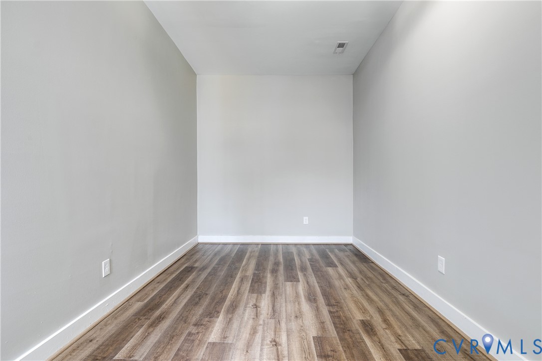 Interior space featuring neutral wall paint and wood-finish flooring