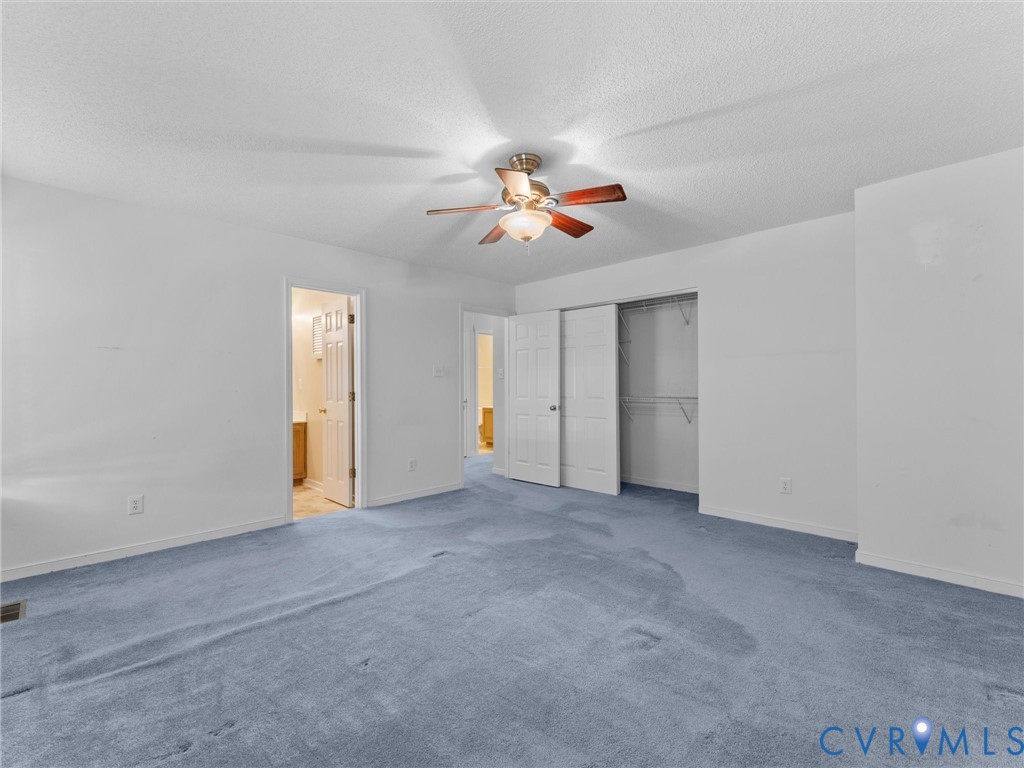 Room featuring wall-to-wall carpeting, a central ceiling fan with integrated lighting, and a closet with double-panel doors