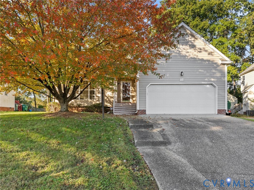 Siding exterior featuring a two-car garage, concrete driveway, and covered front entryway with steps