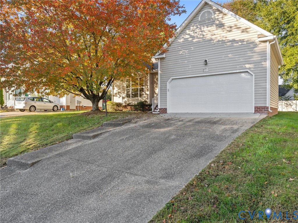 Exterior featuring horizontal siding, a gabled roofline, brick foundation accents, a concrete driveway, and an attached two-car garage