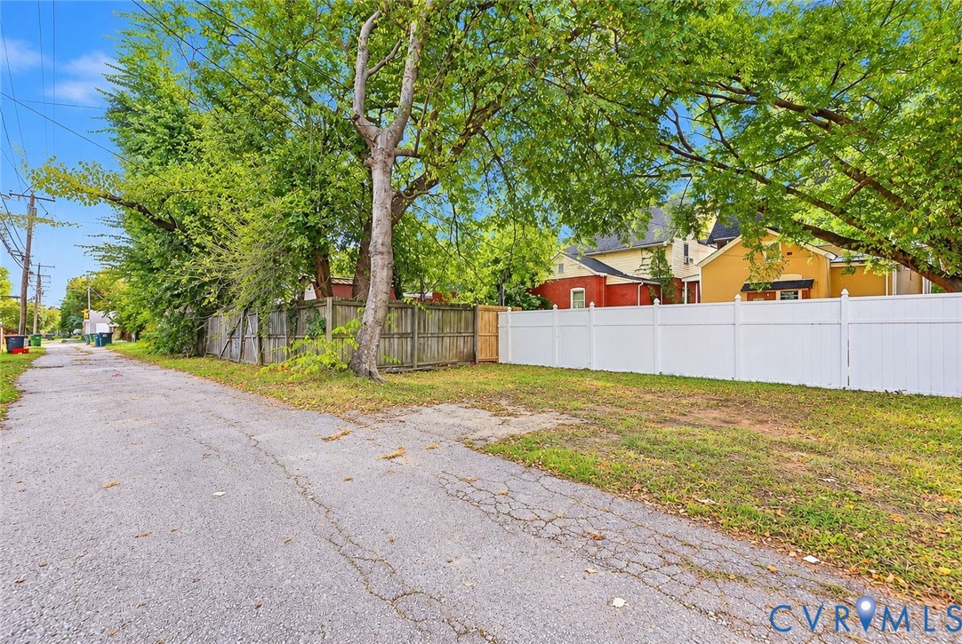 Exterior lot featuring white vinyl fencing, wood perimeter fencing, and mature trees Exterior lot featuring white vinyl fencing, wood perimeter fencing, and mature trees