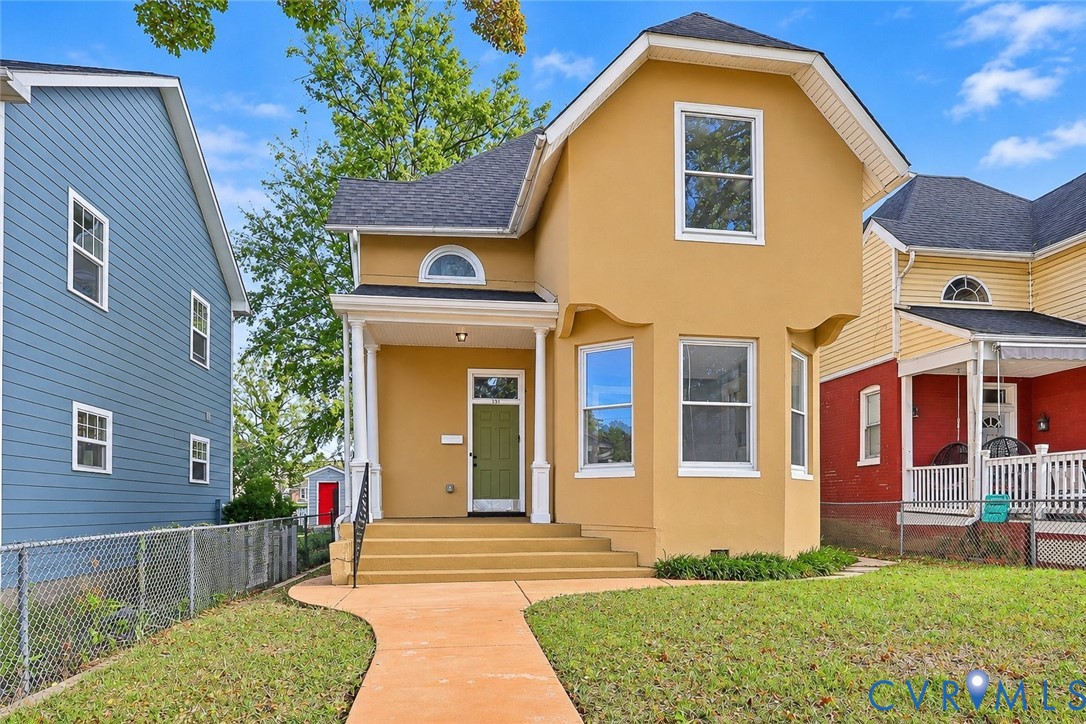 Stucco exterior with a prominent bay window, covered front porch, arched accent window, and asphalt shingle roof Stucco exterior with a prominent bay window, covered front porch, arched accent window, and asphalt shingle roof