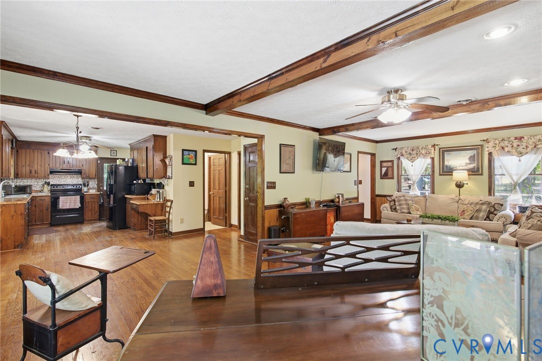 Wood flooring, exposed ceiling beams, recessed lighting, and wooden cabinetry Wood flooring, exposed ceiling beams, recessed lighting, and wooden cabinetry