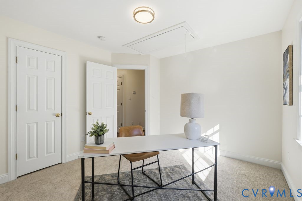 Neutral-toned carpeting, six-panel interior doors, and a recessed ceiling light fixture