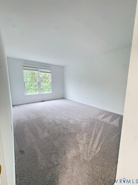 Neutral wall tones, wall-to-wall carpeting, and double-pane window featuring white trim Neutral wall tones, wall-to-wall carpeting, and double-pane window featuring white trim