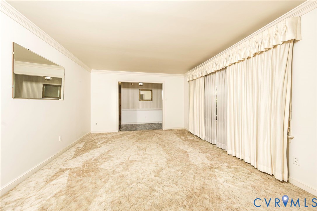 Neutral wall palette featuring crown molding, wall-to-wall carpeting, and floor-to-ceiling window drapery Neutral wall palette featuring crown molding, wall-to-wall carpeting, and floor-to-ceiling window drapery