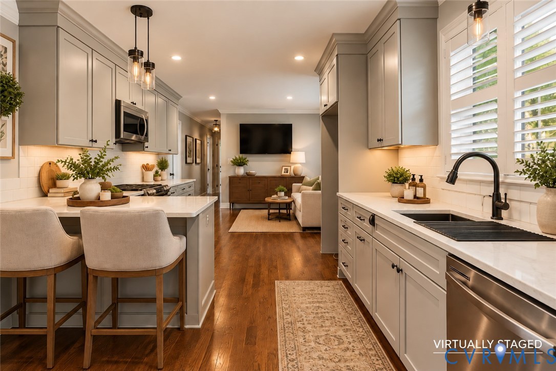 Kitchen featuring light gray cabinetry, quartz countertops, white subway tile backsplash, wood-finish flooring, and matte black plumbing fixtures