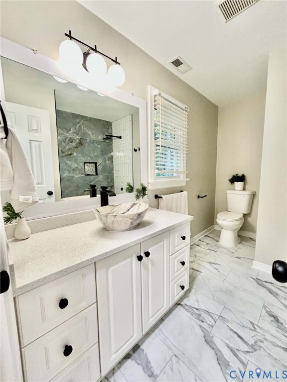 White vanity cabinet with a stone countertop, vessel sink, matte black faucet, and large-format tile flooring