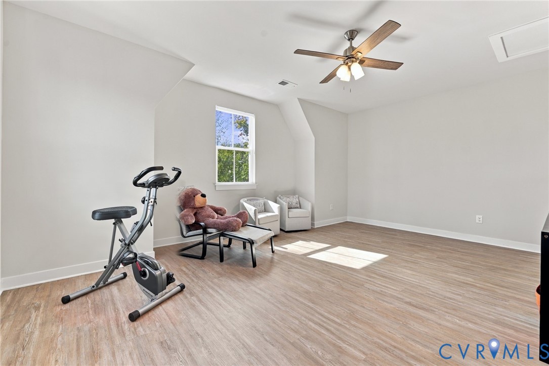 Neutral-toned walls, wood-finish flooring, single-hung window, and ceiling fan with integrated lighting