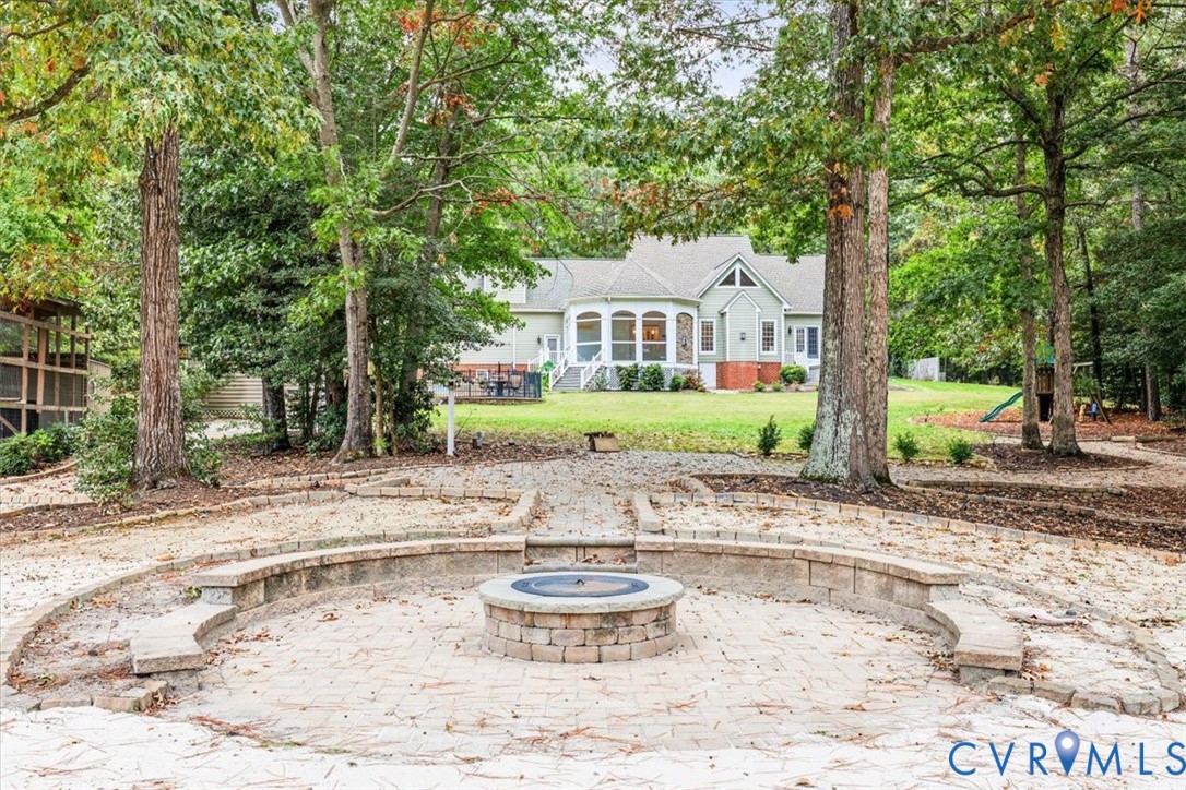 Overlooking the pond, beautiful hardscaping seating area around firepit.