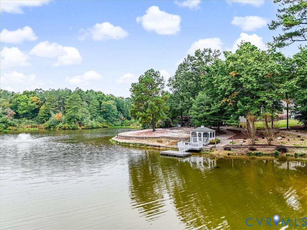 Pond featuring a fountain. Gazebo overlooking pond with dock.