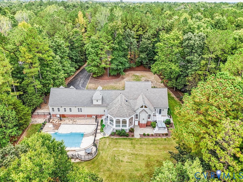 Nice view of the home with the pool, landscaping, hardscaping and patio with hot tub.