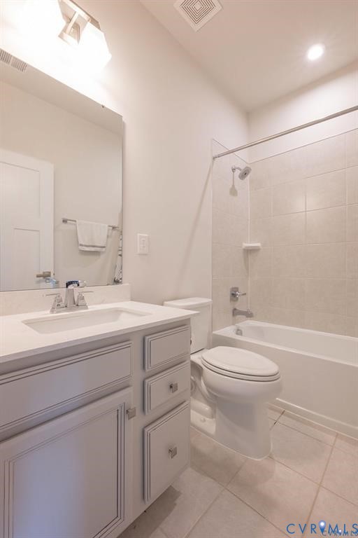 Light gray vanity cabinetry with integrated rectangular sink and stone-finish countertop, paired with a shower-tub combination featuring neutral tile surround and brushed-nickel fixtures