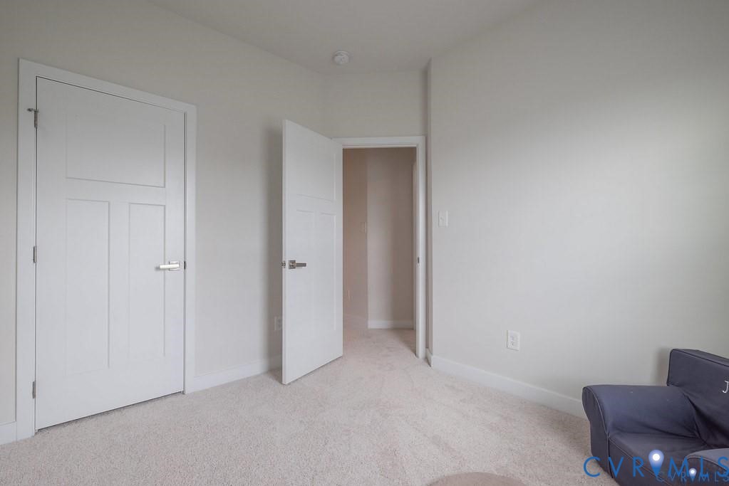 Neutral interior featuring carpeting, light-toned wall finishes, and two-panel shaker-style interior doors with brushed nickel hardware