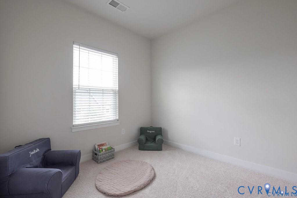 Neutral-toned walls, wall-to-wall carpeting, and a window with horizontal blinds
