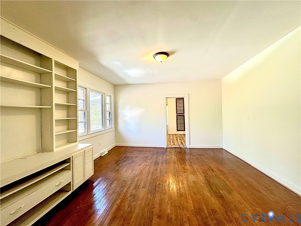 Built-in cabinetry featuring integrated shelving and storage drawers, wood-finish flooring, and multi-pane windows