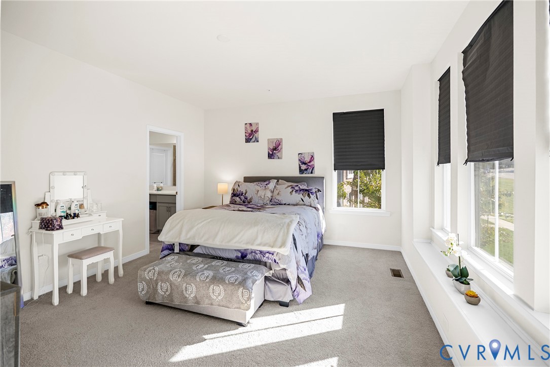Neutral-toned interior featuring wall-to-wall carpeting, multiple windows, and built-in window sills