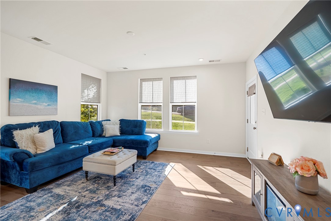 Neutral-toned walls, wood-finish flooring, and multiple dual-pane windows