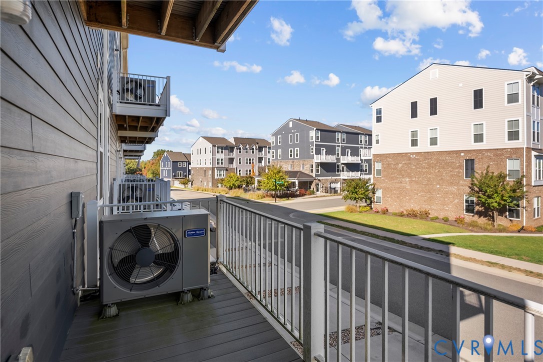 Elevated balcony featuring composite decking, white metal railing, and exterior siding
