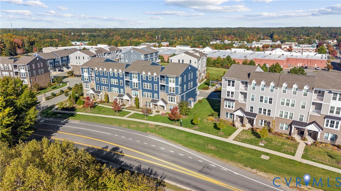 Multi-story residential buildings featuring gabled rooflines, fiber-cement siding, stone veneer facades, and manicured green spaces